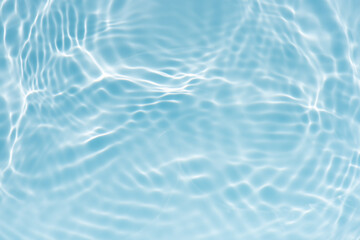 Blue water with ripples on the surface. Defocus blurred transparent blue colored clear calm water surface texture with splashes and bubbles. Water waves with shining pattern texture background.