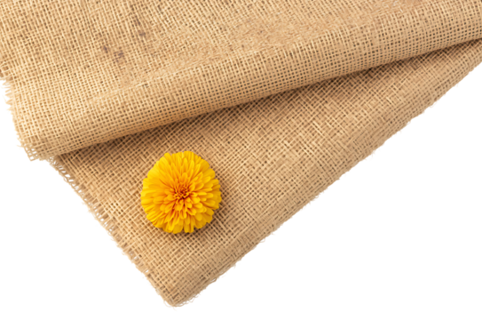 Close up of a textured natural fabric with a small yellow flower detail