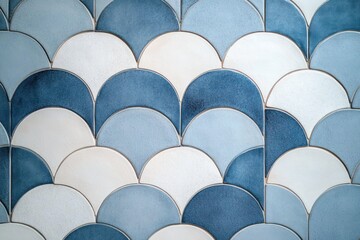 Close-up of overlapping ceramic tiles in varying shades of blue and white with a scalloped pattern creating a textured and harmonious visual effect