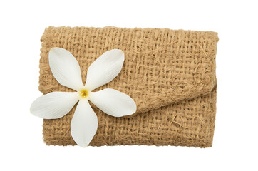White flower on a textured burlap gift box against a black background
