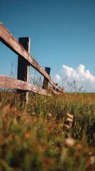 Rustic Wooden Fence in Meadow with Blue Sky and Clouds