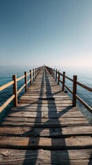 Serene Wooden Pier Extending into Calm Blue Water at Sunrise