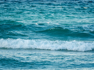 A stunning shot of a large clean wave breaking in the turquoise sea creating a tube and a crest of white foam a perfect surfing background