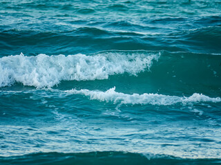 A large beautiful wave of turquoise water curls and breaks in the sea creating a dynamic and powerful image of nature's energy