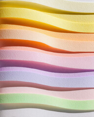 Colorful layered paper cutouts create wavy gradient pattern in pastel shades, evoking sense of calm and creativity. texture and colors blend harmoniously