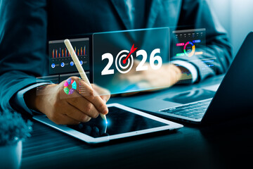 Business professional using digital tablet and futuristic data dashboard showing 2026 target, representing business goal, planning, financial analytics, digital transformation, technology innovation