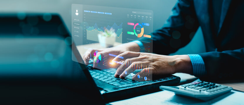 Businessman on laptop with futuristic digital data dashboard, showing charts and analytics graphs, representing financial analysis, business intelligence, big data, technology, digital transformation.