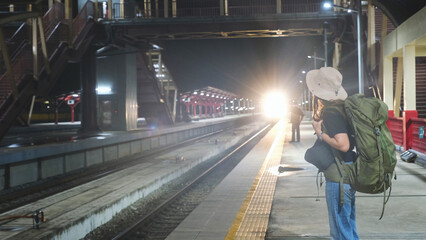 A female backpacker waiting for the train at railway station