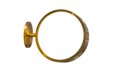 A golden, circular sign with a blank, white face and wall mount against a black background