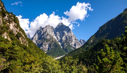 A breathtaking landscape showcasing majestic, snow-dusted mountain peaks framed by lush, verdant forests under a vibrant, cloud-filled sky