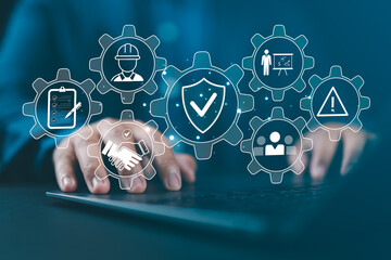 Work Safety and Compliance Concept. Man typing on a laptop with icons work safety, compliance, risk management, operational efficiency, health protocols, workplace regulatory, and safety standards.