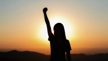 Strong confident woman! Winning and life goals concept. Silhouette of a person raising a fist against a sunset backdrop, symbolizing strength and empowerment.