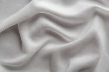 Obraz premium Close-up of soft, light gray fabric with gentle folds and texture creating a smooth, flowing pattern under soft lighting