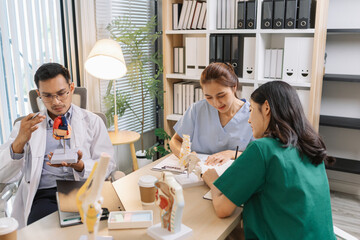 Doctor teaching medical team during a clinical session. Healthcare professionals learn together, discussing anatomy models and patient cases to enhance medical knowledge and treatment skills.