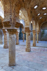 Ancient moorish architecture with brickwork arches, columns, and star-shaped openings in the historic arab baths in ronda,malaga,spain