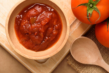 Tomato sauce for cooking Italian and Mediterranean food such as pasta and pizza, placed on a brown background