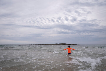 Small child in surf using imagination