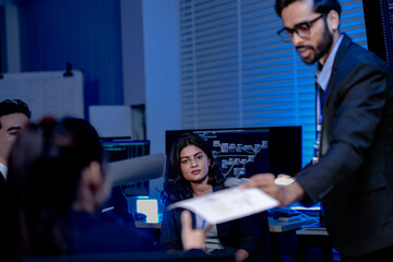 During a corporate seminar QA session an engaged male professional asks a question while his diverse and smiling colleagues listen showcasing a moment of team success and positive engagement.