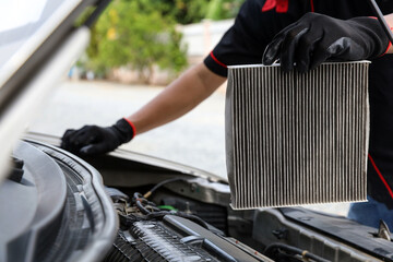 Auto mechanic holding car air conditioner filter for check and clean dirty or fix repair heat have engine problem or replace new change air filter of car care maintenance servicing concepts.