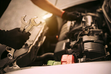Auto mechanic holding wrench for fix service repairing and car care maintenance servicing change spare part engine problem or insurance support or range of car check or training workshop.