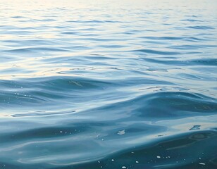 Calm ocean waves reflecting sunlight on a tranquil sea surface at dawn