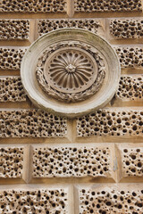Brick wall hole with circular art sculpture as background.