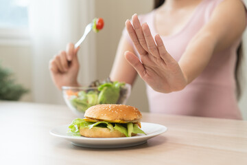 A person who avoids eating high-calorie junk food in high calories to control cholesterol and sugar...