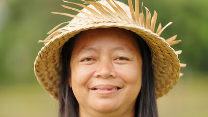 closeup portrait, indonesian woman farmer in rural indonesia wearing straw hat, smiling face, looking at camera, missing tooth, adult, southeast asia, asian people