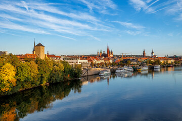 Obraz premium Würzburg cityscape with river and historic churches on a clear autumn day.