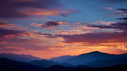 Obraz premium Layered mountain silhouettes contrast against a vibrant, colorful twilight sky.