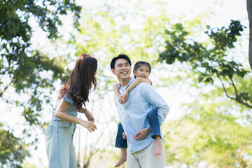 Fototapeta premium Asian family enjoying a picnic in the park on a sunny weekend.