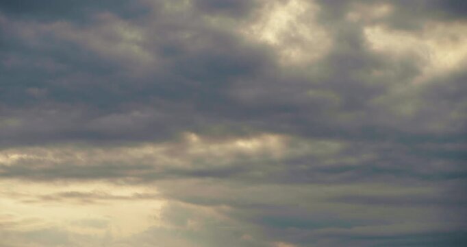 Glowing Sunset Clouds Motion &ndash; Timelapse capture of dramatic cloudscape illuminated with warm evening tones.