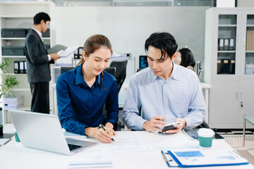 Obraz premium Young Asian professionals collaborating in modern office, discussing business strategy, teamwork, and success. Perfect for corporate, startup