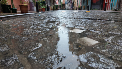Rainwater collects on cobblestone street after a gentle rain
