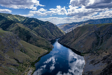 Drone photo of calm surface of Snake river, Hells Cayon. Clouds reflection in blue water © Dmitry