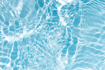 Blue water with ripples on the surface. Defocus blurred transparent blue colored clear calm water surface texture with splashes and bubbles. Water waves with shining pattern texture background.