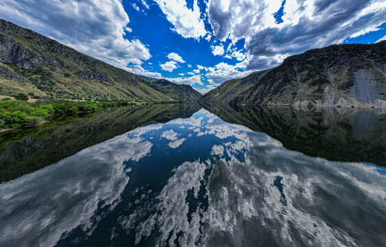 Drone photo of calm surface of Snake river, Hells Cayon. Clouds reflection in blue water