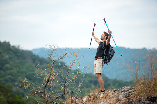 Hiker man backpack raise hands and walking trail activity camping outdoors for destination leisure.  People happy feeling freedom good and strong weight victorious facing on the natural mountain