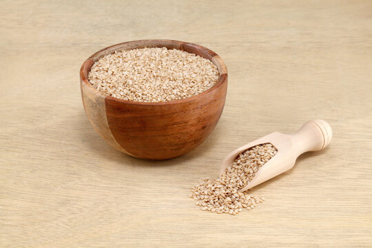 White sesame seeds in wooden bowl and scoop - Powered by Adobe