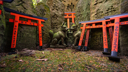 The shot captures a serene Japanese shrine nestled in a lush forest, featuring numerous traditional...