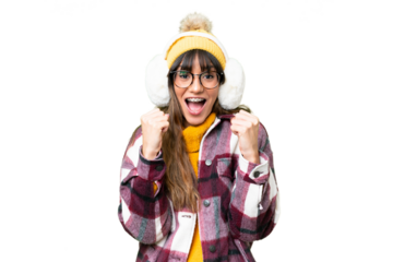 Young caucasian woman wearing winter muffs over isolated chroma key background celebrating a victory in winner position