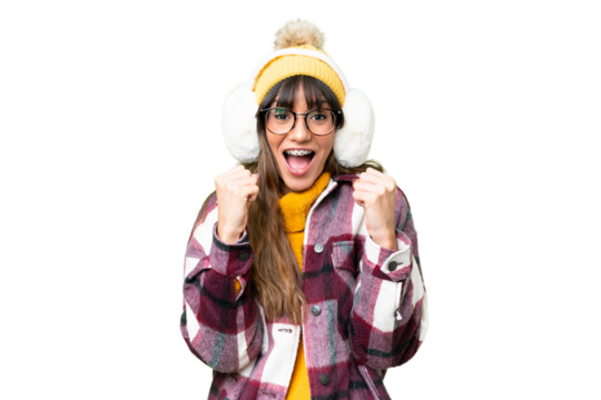 Young caucasian woman wearing winter muffs over isolated chroma key background celebrating a victory in winner position