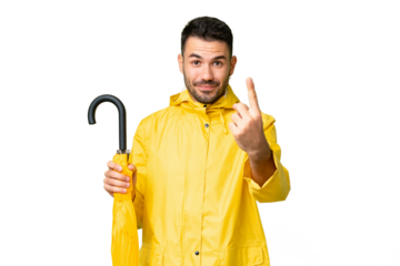 Young caucasian man with rainproof coat and umbrella over isolated background doing coming gesture
