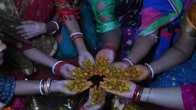Hands of Women holding turmeric paste and betel nut during indian wedding ceremony, haldi ceremony in an Indian wedding. handheld shot