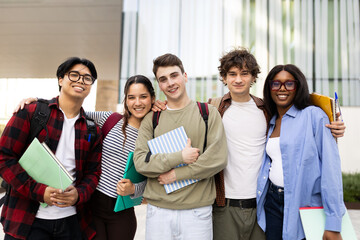Obraz premium Happy university or high school students hugging and holding books
