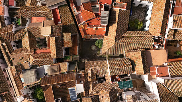 Fototapeta Aerial drone view of traditional tiled houses roofs and streets from above, old medieval town background, Spain