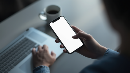Transparent person using a smartphone with a blank screen while working on a laptop, modern technology and communication concept mockup