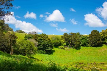 People walking and hiking on top of extinct volcano mountain under blue sky summer time.