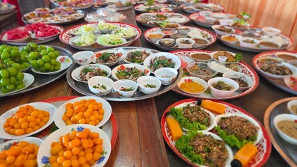 Colorful Traditional Feast with Various Dishes and Fresh Ingredients on Dining Tables