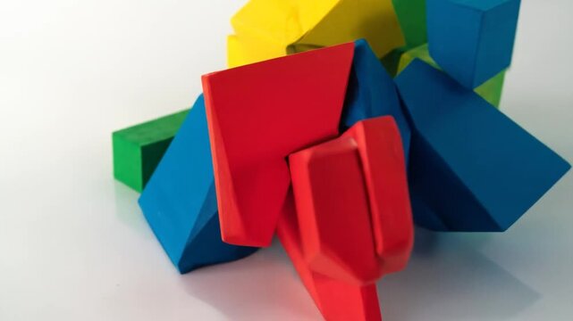 A vibrant abstract composition features interlocking colorful blocks on a bright white surface